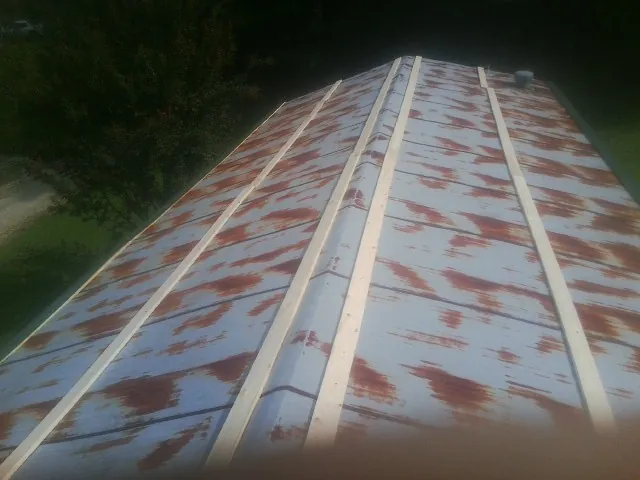 Rusted metal roof panels with new wood purlins before replacement — Storm Damage Roof Repair in Lewistown by Roofing Brothers