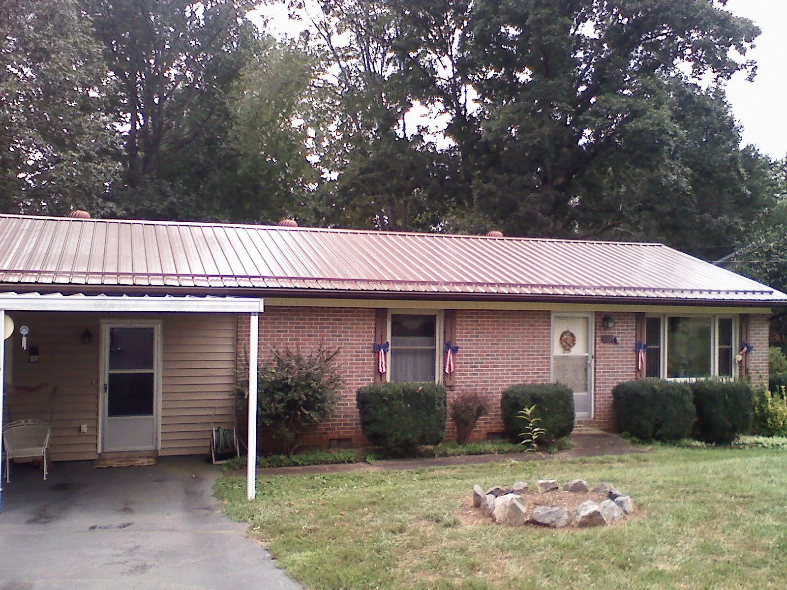 Bronze metal roof and carport on a brick ranch home — Roof Repair work by our crew in Lewistown